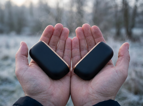 Two warmer halves held in cupped hands outdoors in frost
